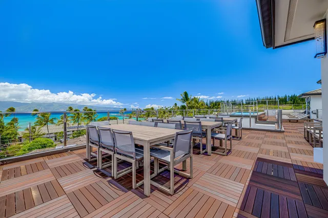 a view of a patio with table and chairs with wooden floor and fence