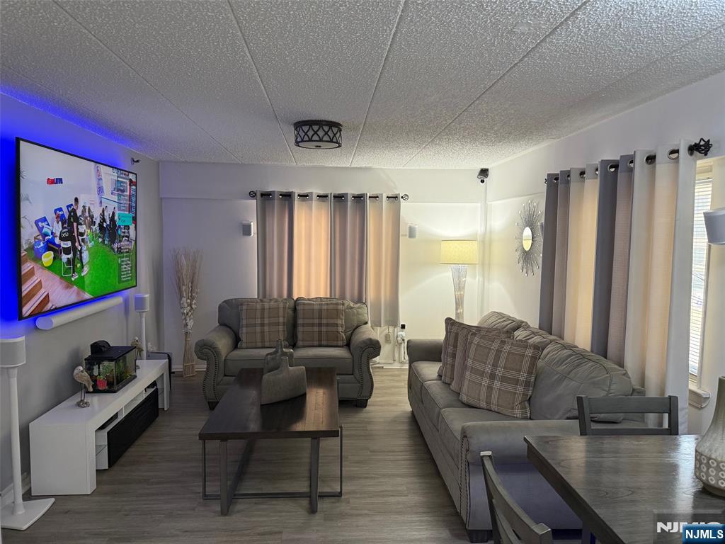 47 Polifly Road, Unit 1D Hackensack, NJ 07601 - Photo 2 of 8 a living room with furniture and a flat screen tv