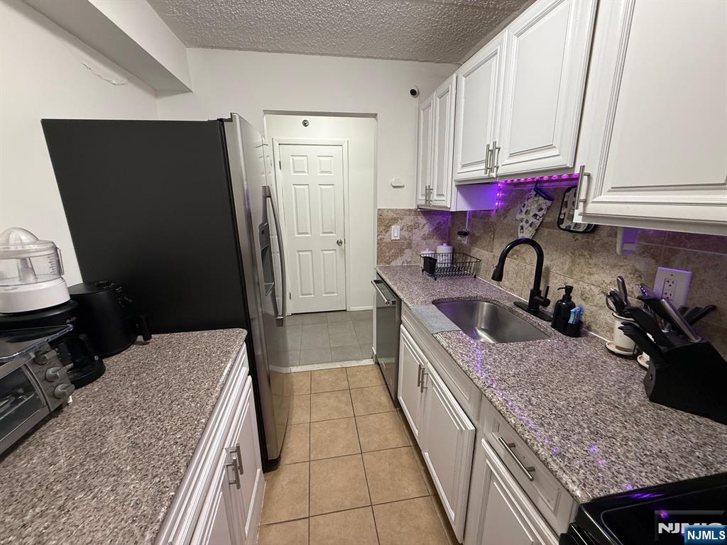 47 Polifly Road, Unit 1D Hackensack, NJ 07601 - Photo 8 of 8 a kitchen with a sink stove and refrigerator