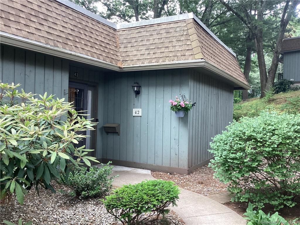 a view of small house with a lot of flower plants