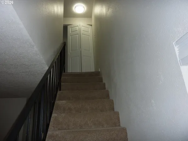 a view of staircase with white walls and railing