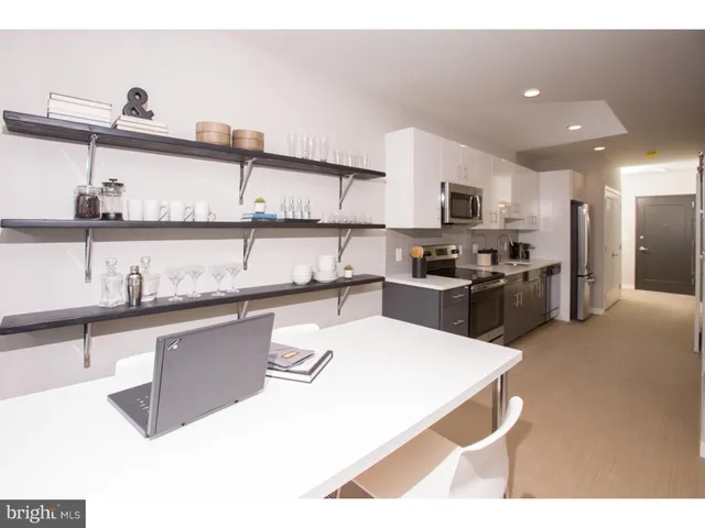 a kitchen with stainless steel appliances kitchen island granite countertop a refrigerator and a sink