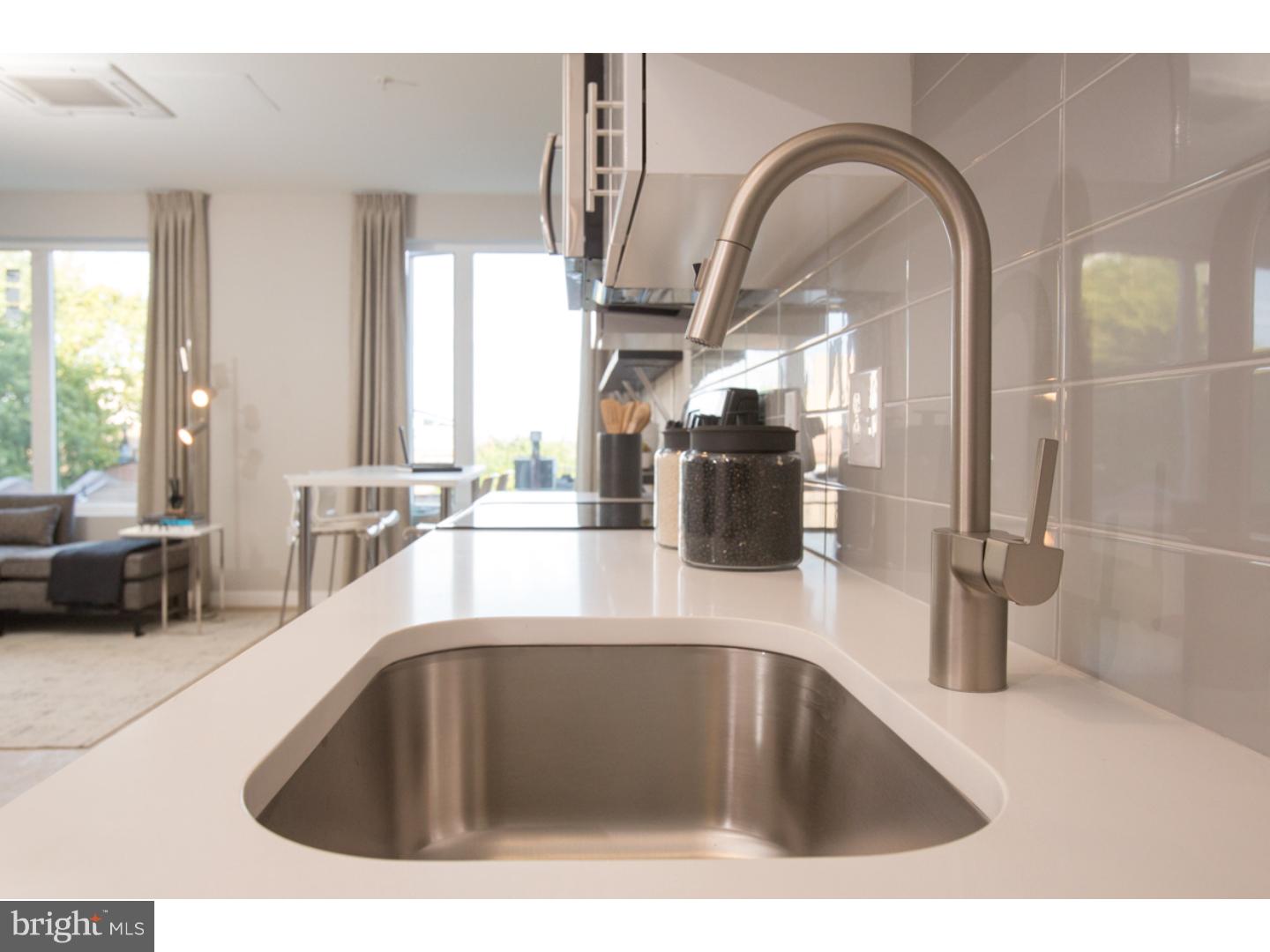 121 North 2nd Street, Unit 214 Philadelphia, PA 19106 - Photo 9 of 17 a kitchen with a sink and a large mirror next to a window