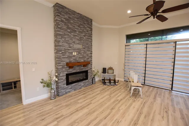 a view of a living room a dining room wooden floor and a ceiling fan