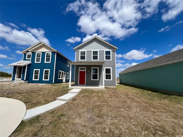 a front view of a house with yard and large trees