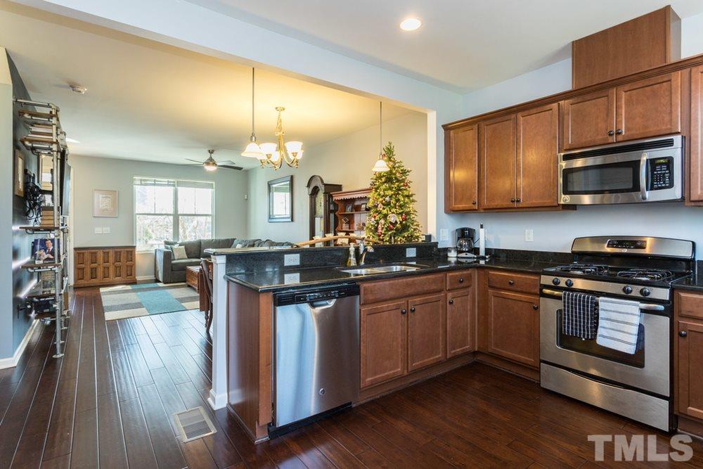 1619 Crafton Way Raleigh, NC 27607 - Photo 13 of 25 a kitchen with stainless steel appliances granite countertop a stove a sink dishwasher and microwave with wooden floor