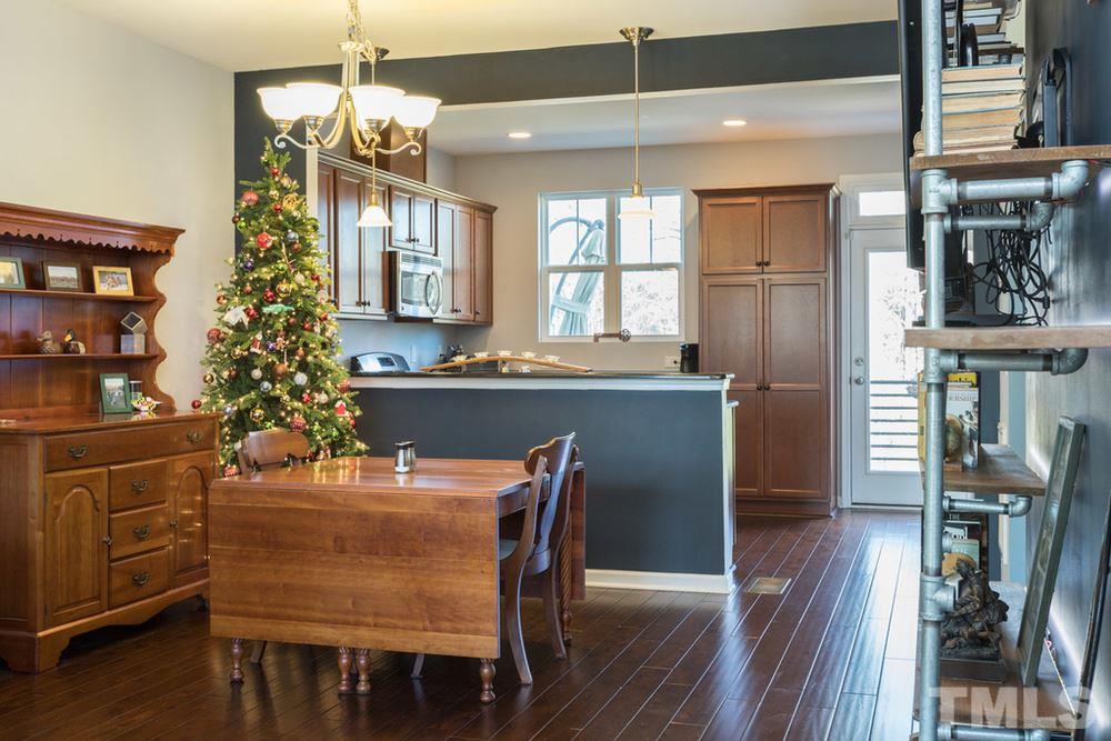 1619 Crafton Way Raleigh, NC 27607 - Photo 10 of 25 a dining room with wooden floor a chandelier a wooden table and chairs