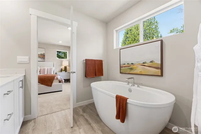 a white tub sitting next to a bathroom sink