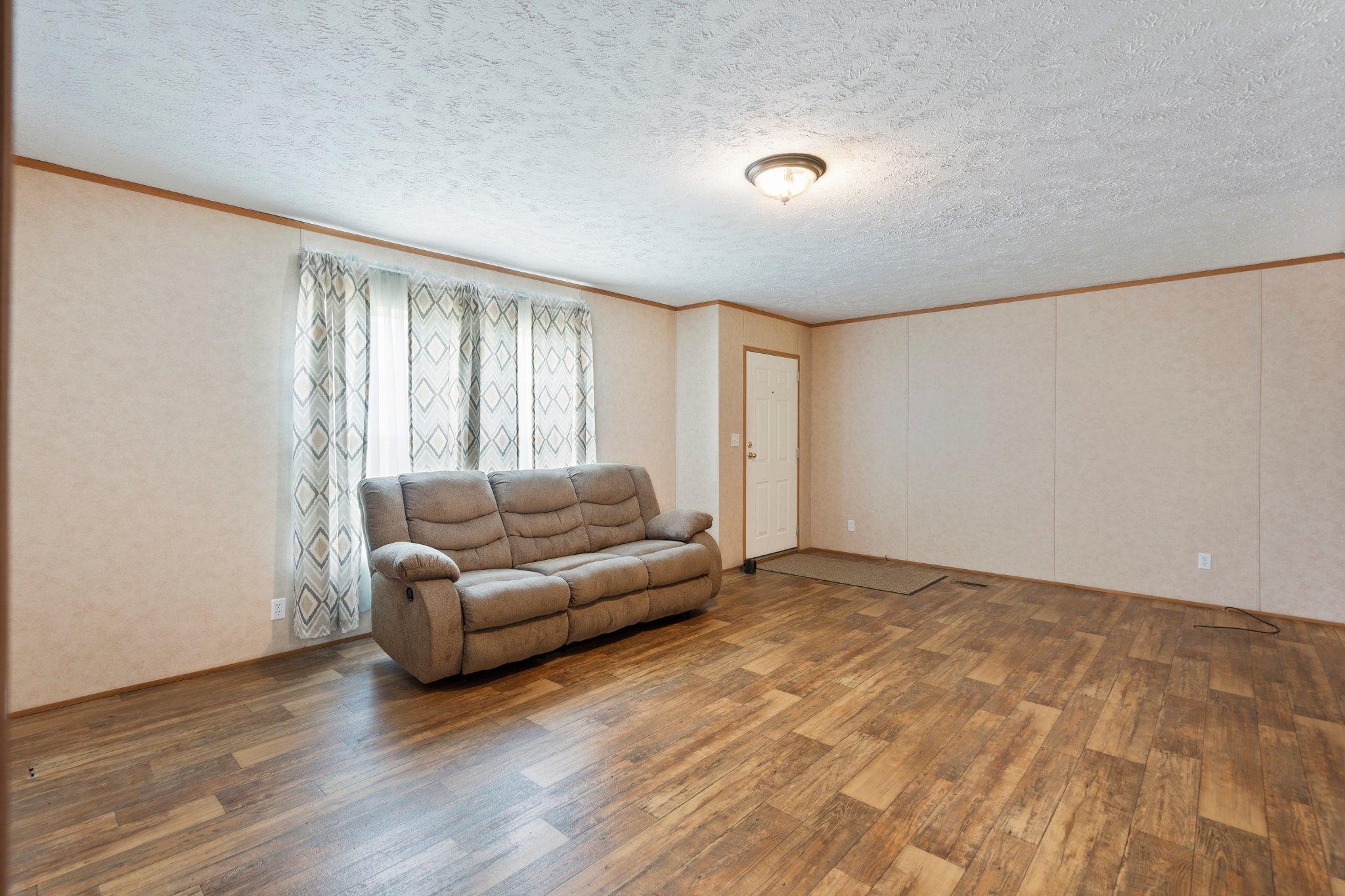 171 Buckner Road Philadelphia, TN 37846 - Photo 11 of 27 a living room with a couch and a dresser next to a window