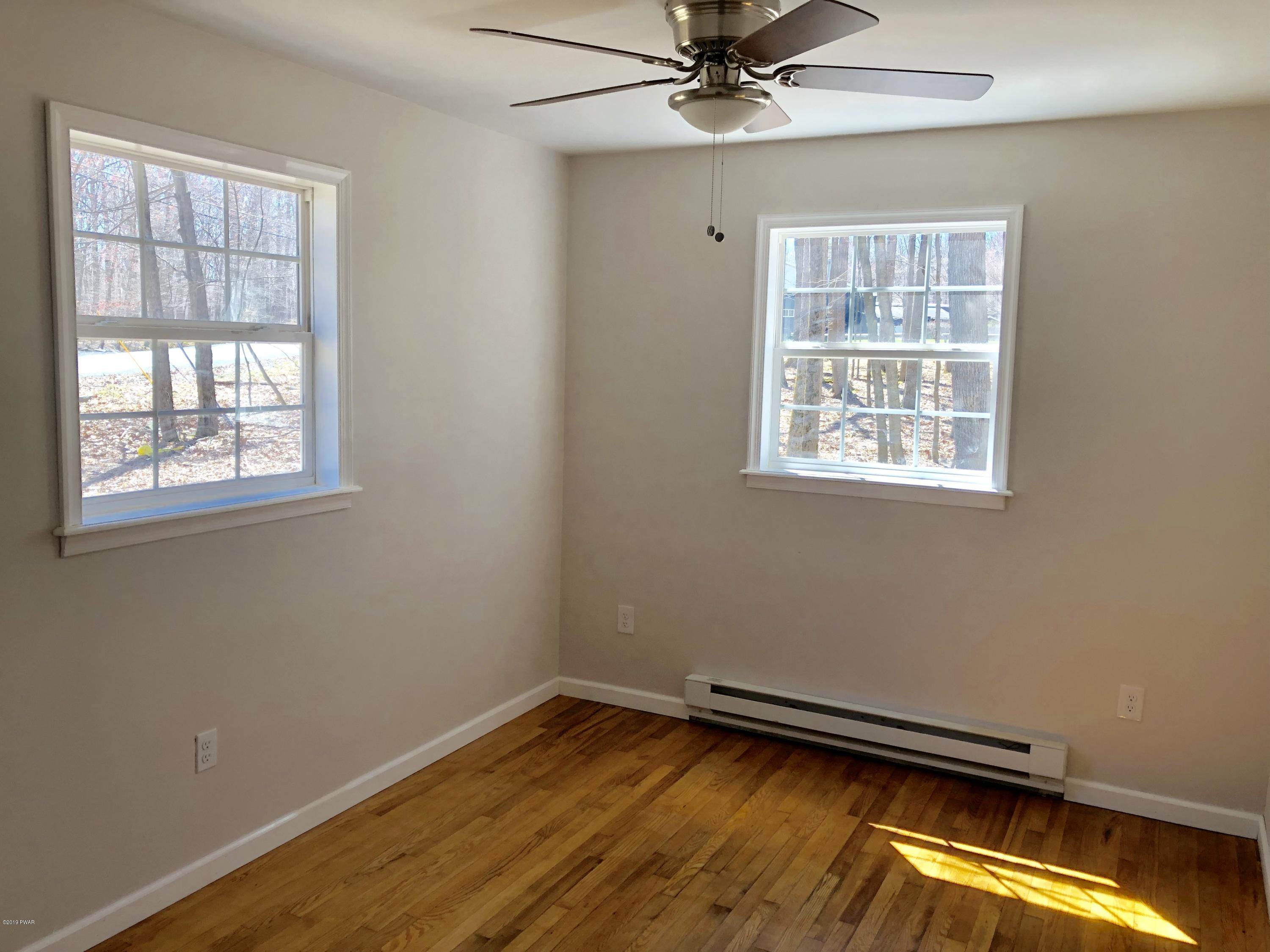 129 Slaymaker Road Milford, PA 18337 - Photo 7 of 13 a view of an empty room with a window and wooden floor