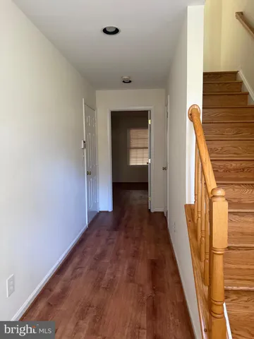 a view of a hallway with wooden floor and stairs