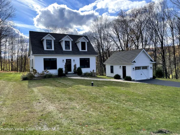 a view of a big house with a big yard and large trees