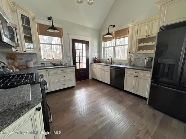 a large kitchen with stainless steel appliances granite countertop a stove refrigerator and a stove top oven