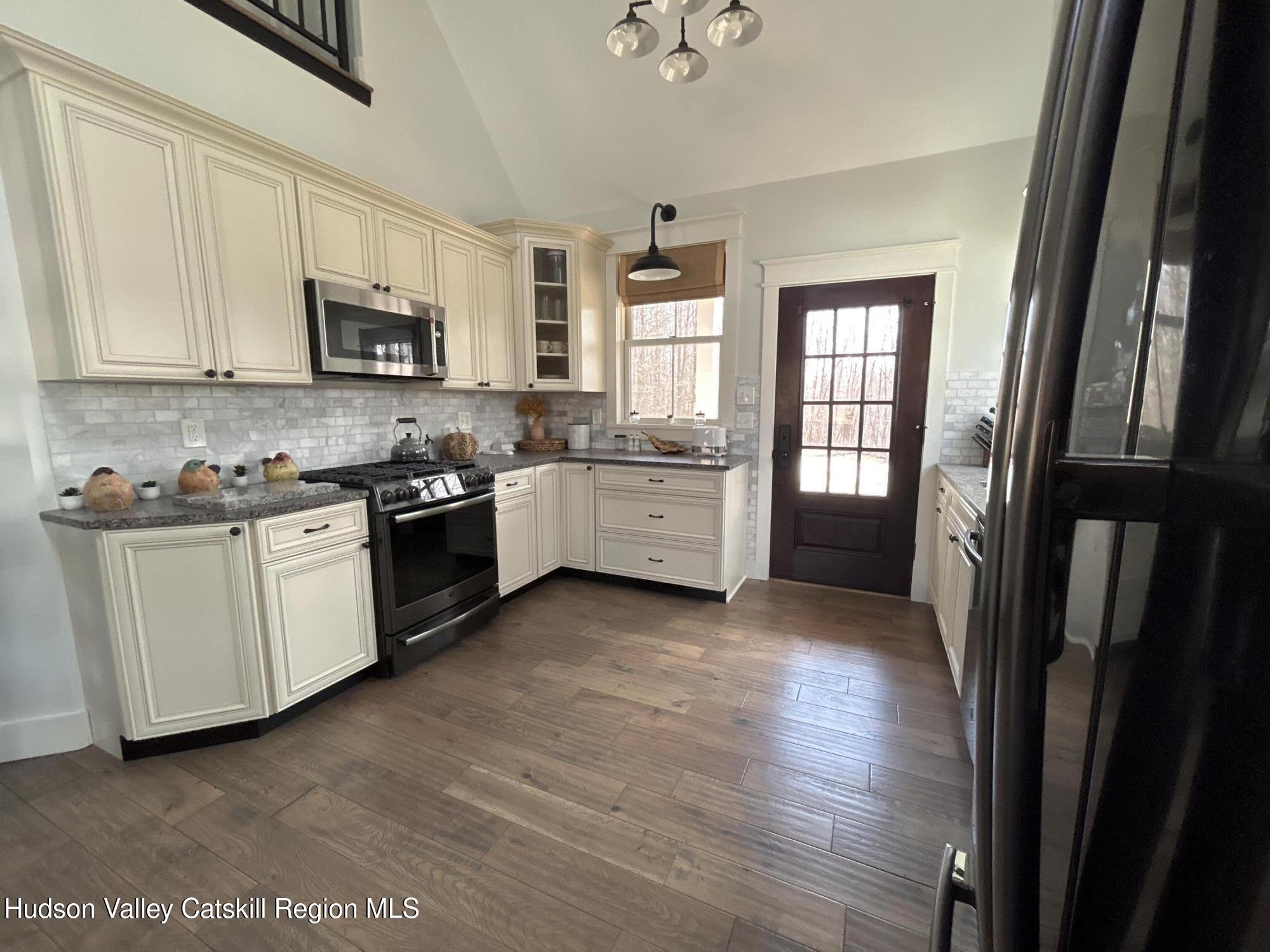 106 Beilke Road Millerton, NY 12546 - Photo 5 of 10 a kitchen with white cabinets and wooden floor