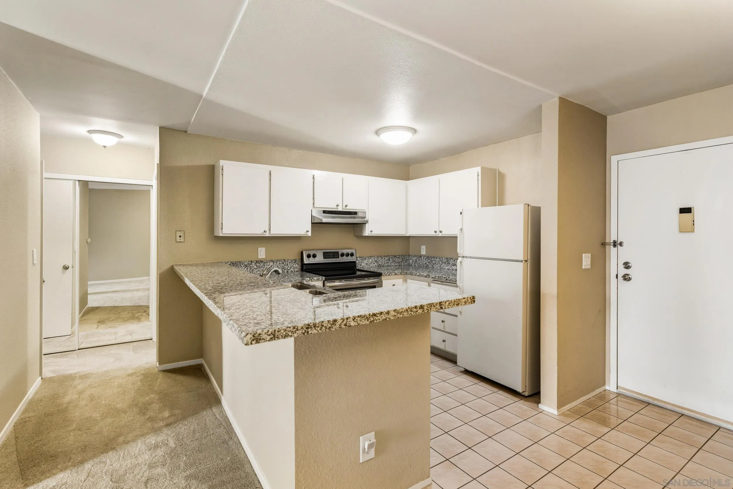 6255 Rancho Mission Road, Unit 217 San Diego, CA 92108 - Photo 6 of 23 a kitchen with a refrigerator a microwave and cabinets