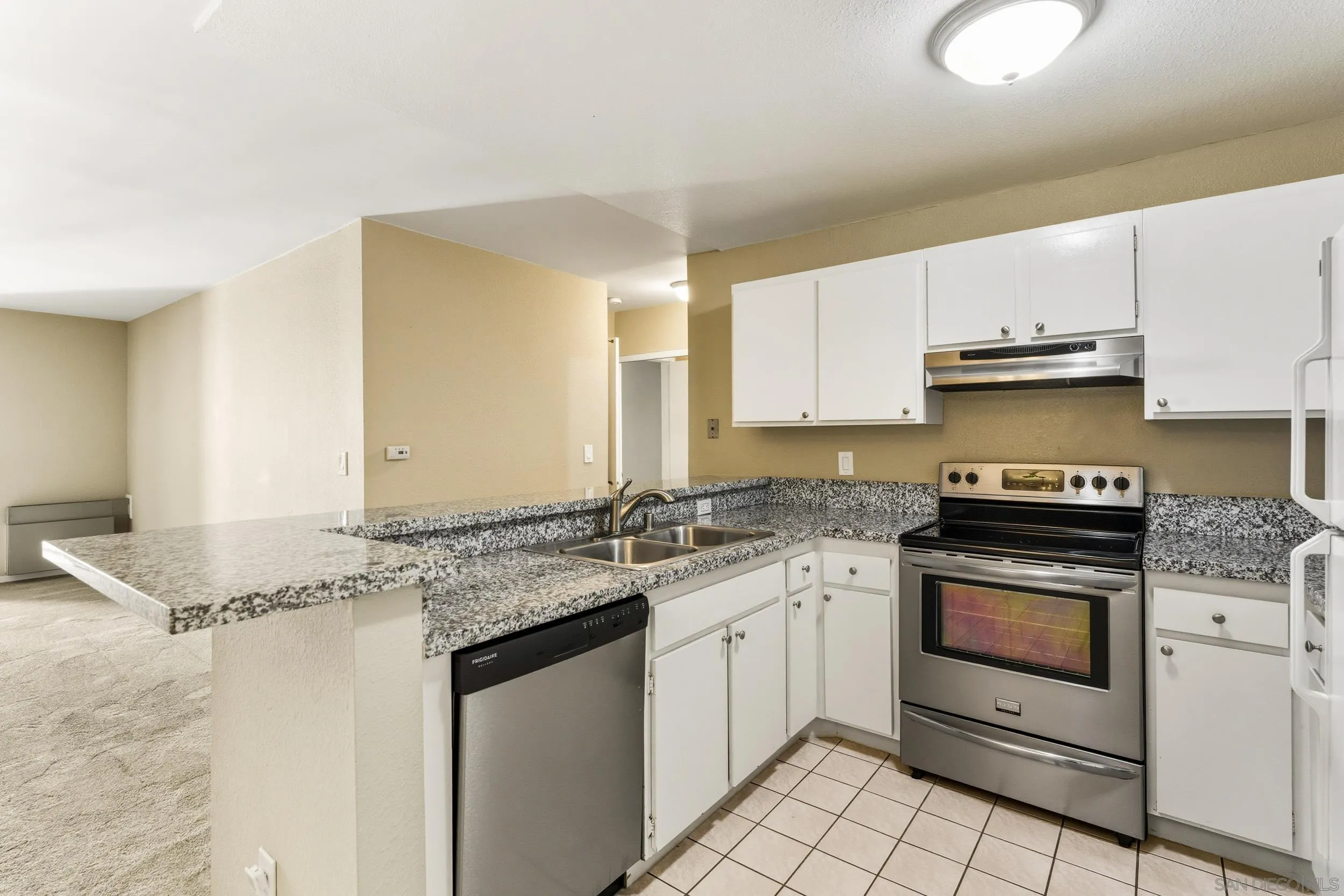 6255 Rancho Mission Road, Unit 217 San Diego, CA 92108 - Photo 7 of 23 a kitchen with stainless steel appliances granite countertop a sink stove and cabinets