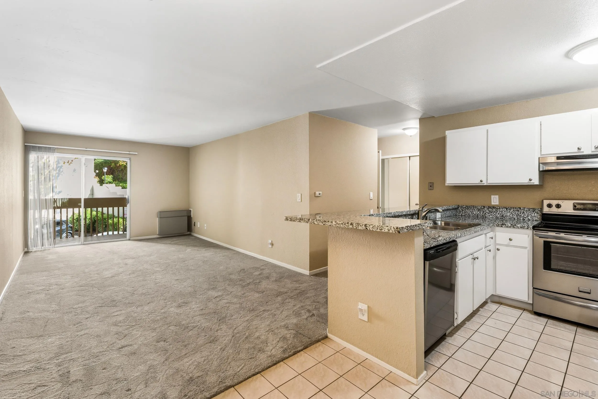 6255 Rancho Mission Road, Unit 217 San Diego, CA 92108 - Photo 9 of 23 a kitchen with a stove a sink and a refrigerator