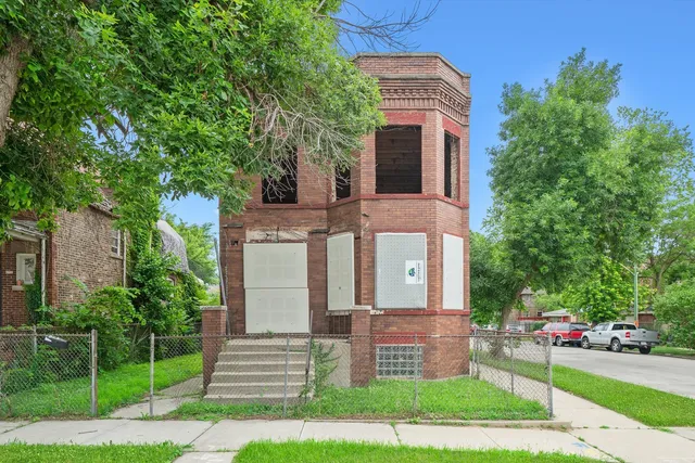 a front view of a house with a garden and trees