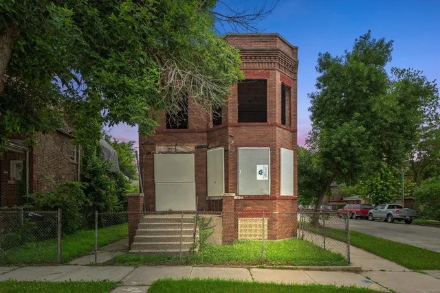 a front view of a house with a garden and plants