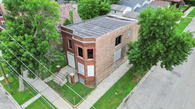 a aerial view of a house with a yard table and chairs