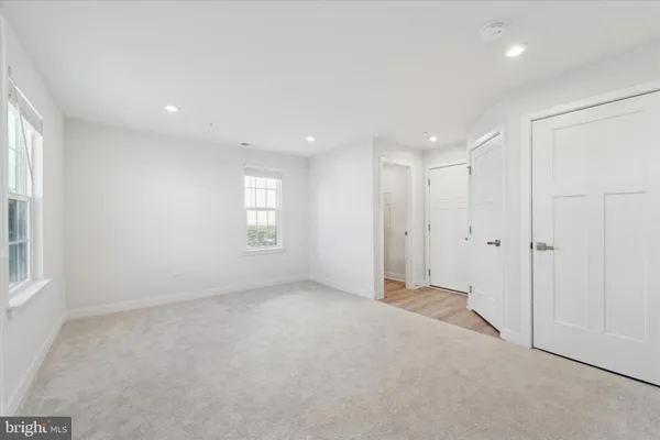 an empty room with windows and closet