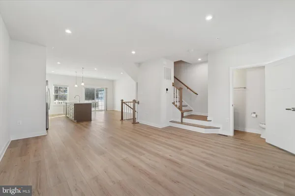 a view of a living room and kitchen with furniture and wooden floor