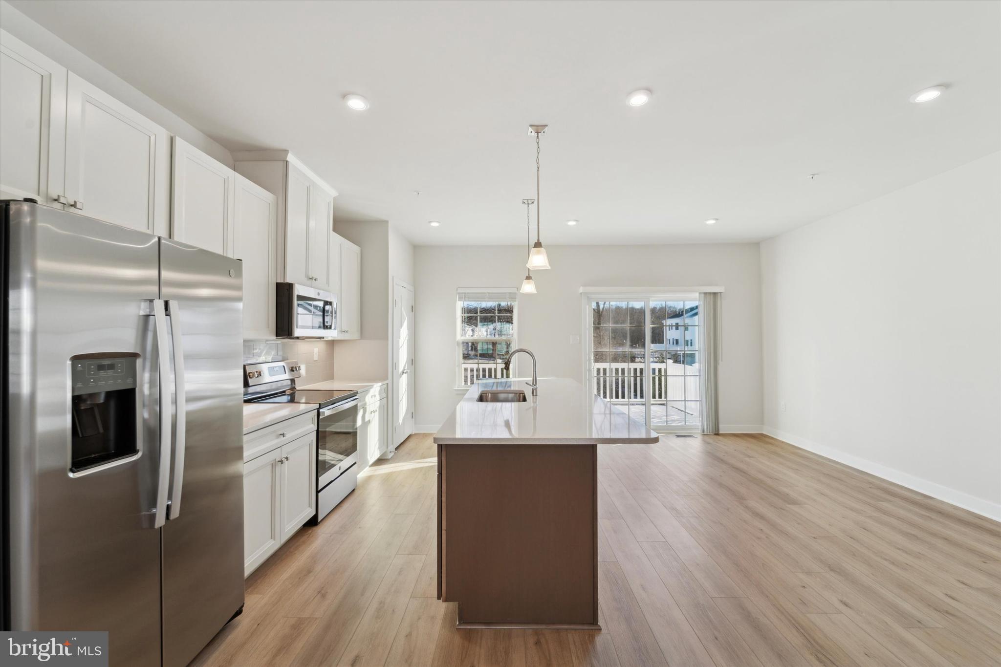 208 River Birch Way Exton, PA 19341 - Photo 8 of 25 a kitchen with stainless steel appliances granite countertop a refrigerator a sink dishwasher a stove and white countertops with wooden floor