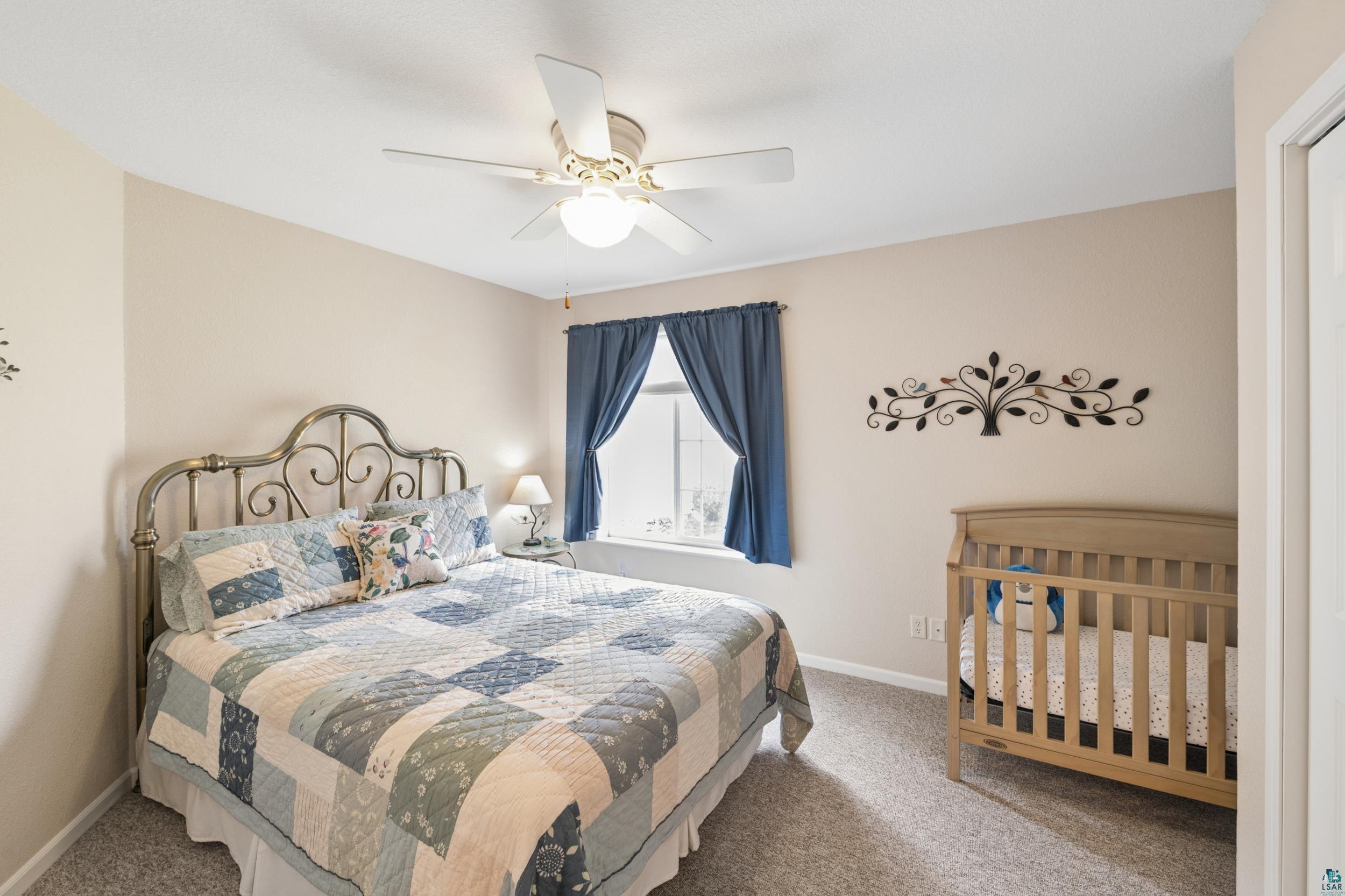 34590 Bay View Road, Unit 801 Bayfield, WI 54814 - Photo 19 of 36 Room featuring a ceiling fan with integrated lighting, a window with blue drapes, and neutral wall paint