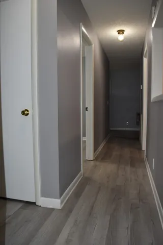 an empty room with wooden floor and bathroom