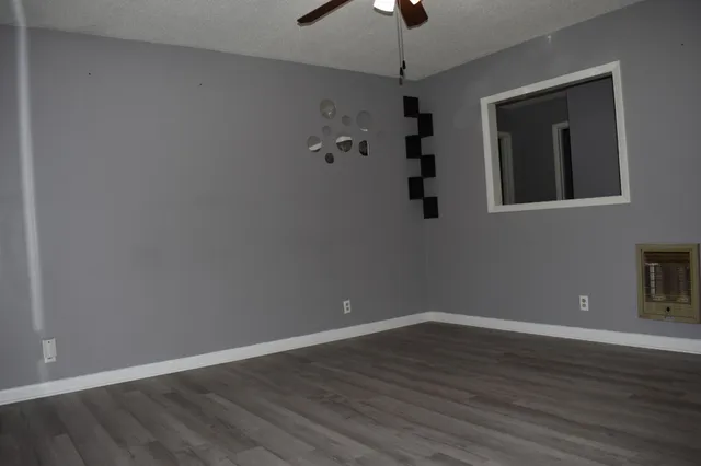 a view of an empty room with wooden floor and closet
