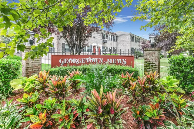 a sign that is sitting in front of a tree