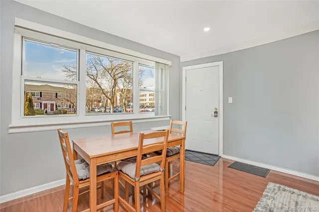 a dining room with wooden floor and window