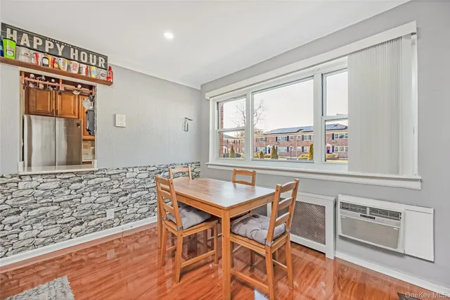 a dining room with a wooden floor and large windows