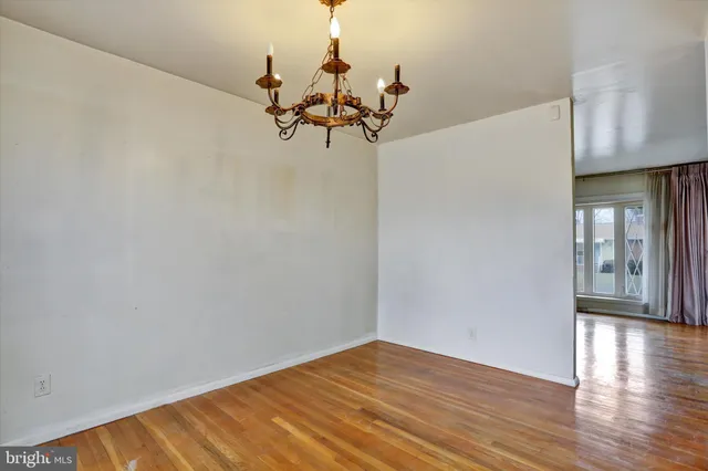 a view of a room with wooden floor and a chandelier
