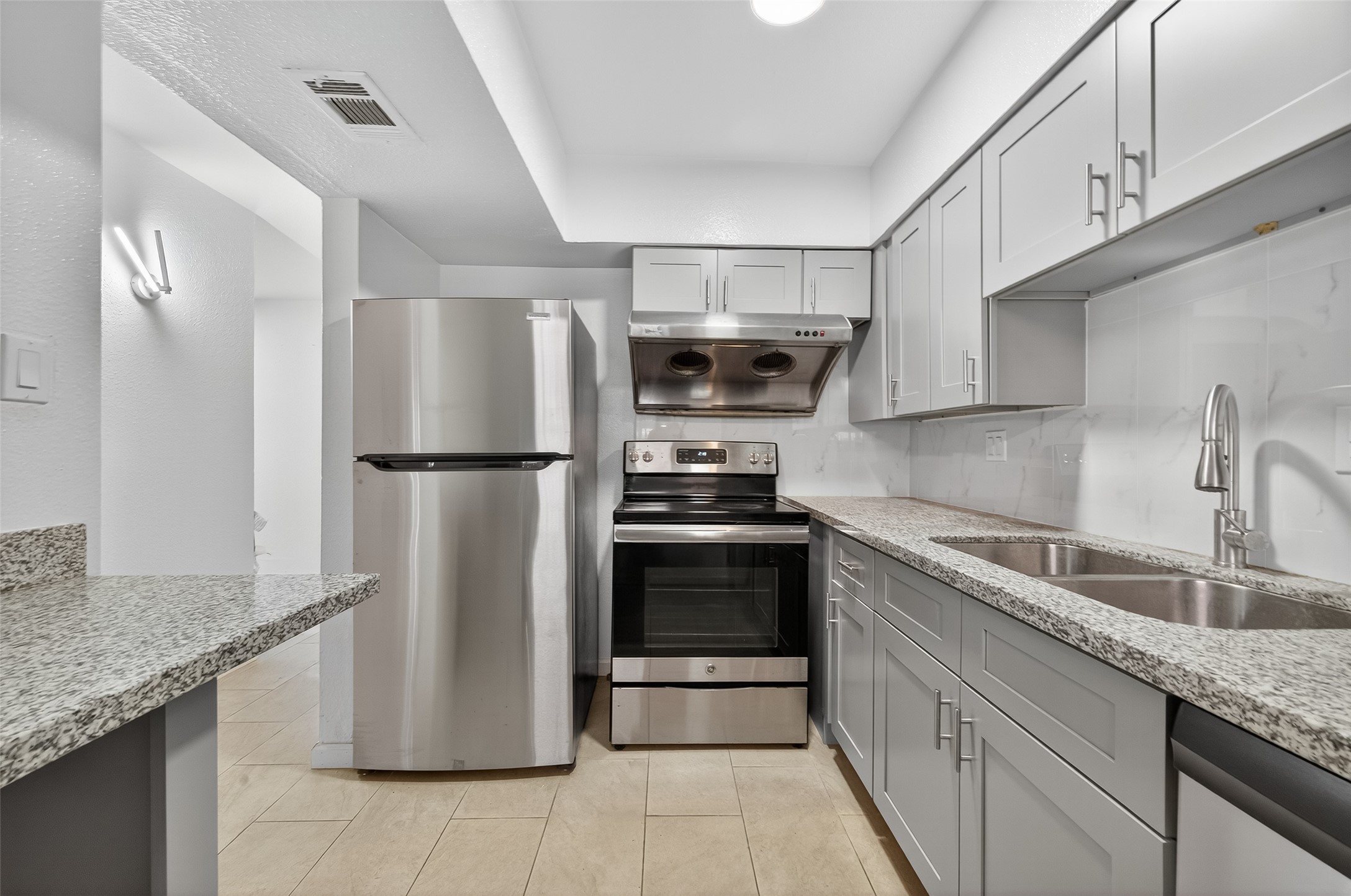 a kitchen with stainless steel appliances granite countertop a refrigerator and a sink