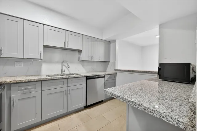 a kitchen with granite countertop a sink and a stove