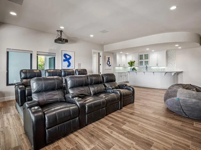 a view of a patio with couches table and chairs with wooden floor and fence