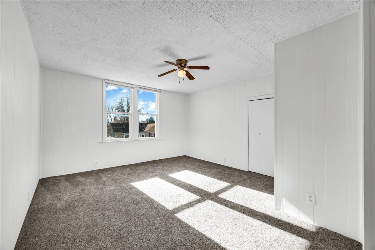 340 East Baker Street Bloomington, IL 61701 - Photo 16 of 28 an empty room with wooden floor and ceiling fan