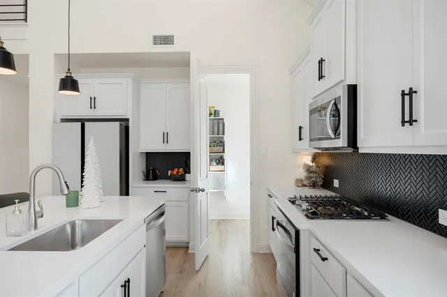 a kitchen with a sink stove and refrigerator