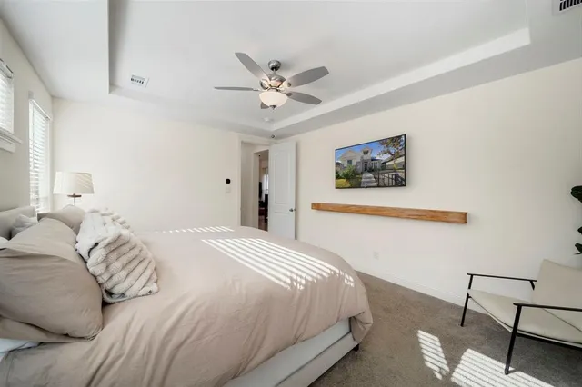 a bedroom with a large bed and a chandelier