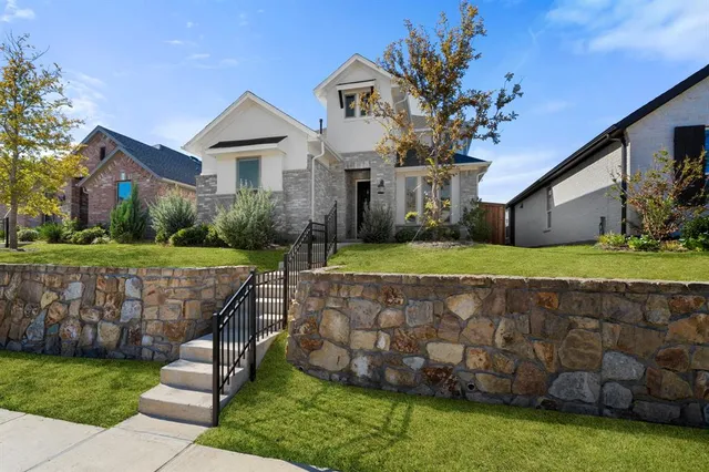 a view of a house with a big yard plants and large trees