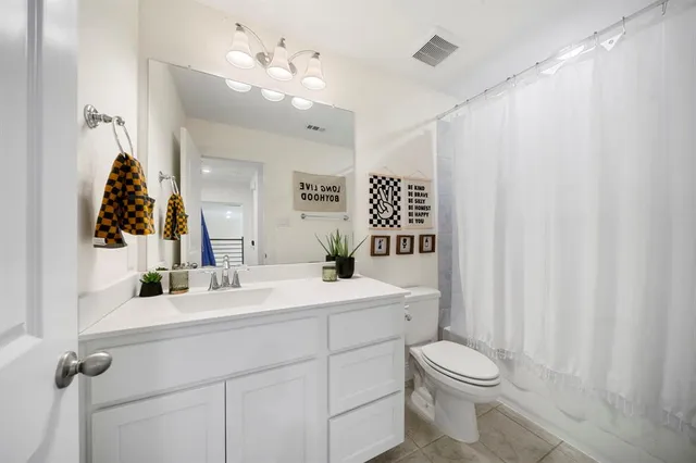 a bathroom with a sink vanity mirror and toilet