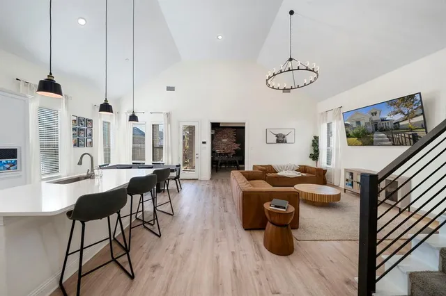 a kitchen with stainless steel appliances granite countertop a stove a sink dishwasher a dining table and chairs with wooden floor