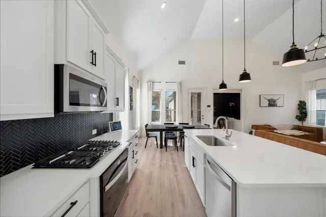 a kitchen with a stove a sink and a refrigerator