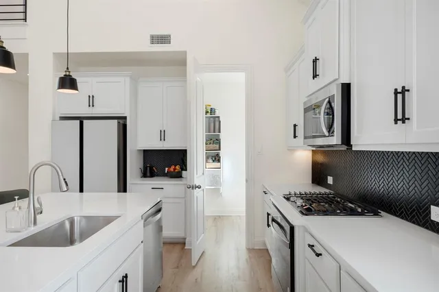 a kitchen with a sink stove and refrigerator