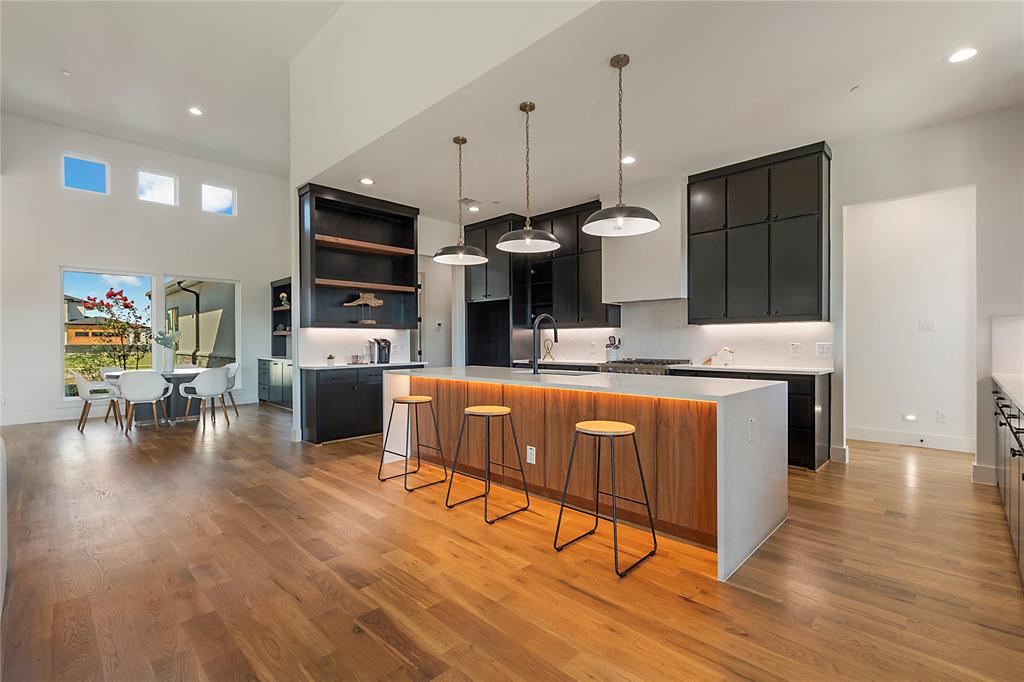 430 Whispering Way Red Oak, TX 75154 - Photo 19 of 40 Gourmet kitchen featuring a large central island with integrated lighting, dark cabinetry, and light countertops