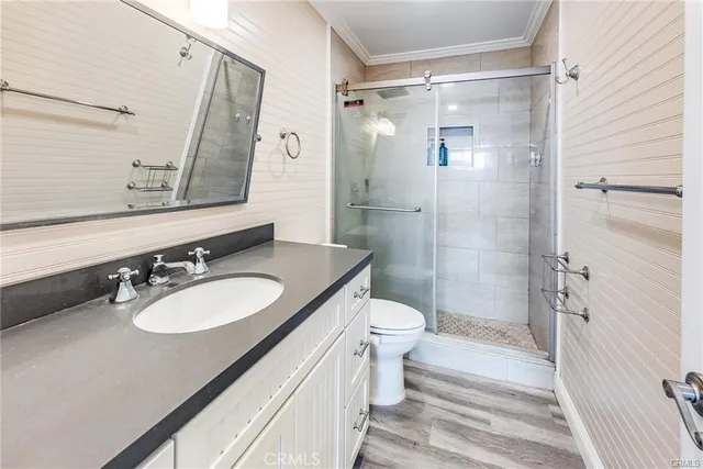 a bathroom with a sink a toilet a mirror and shower
