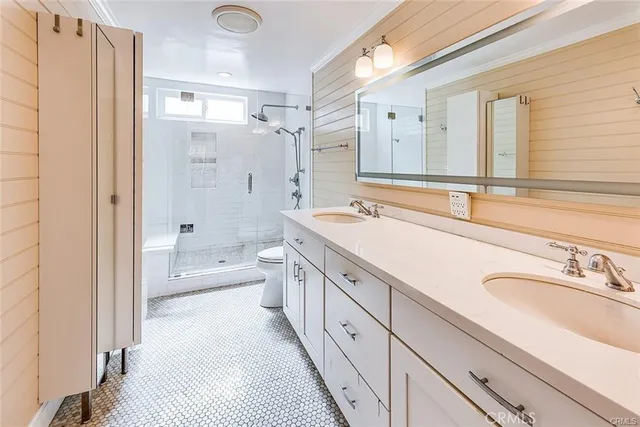 a spacious bathroom with a double vanity sink a mirror a bathtub and shower