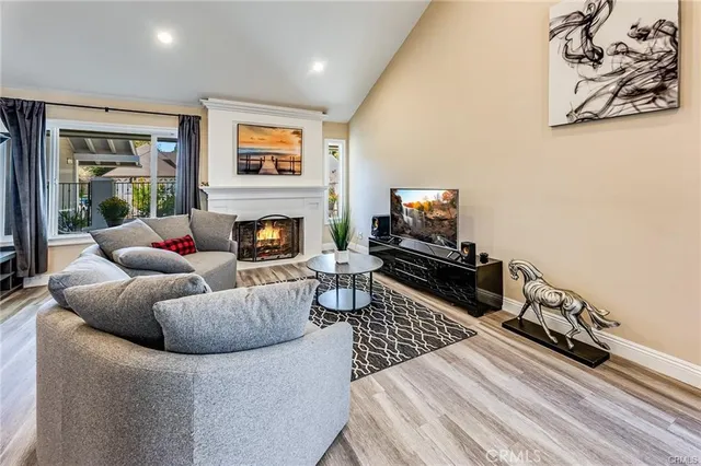 a living room with furniture a flat screen tv and a fireplace