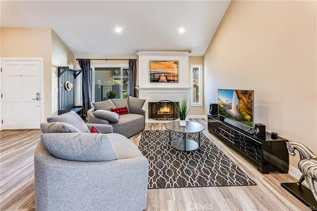 a living room with furniture a flat screen tv and a fireplace